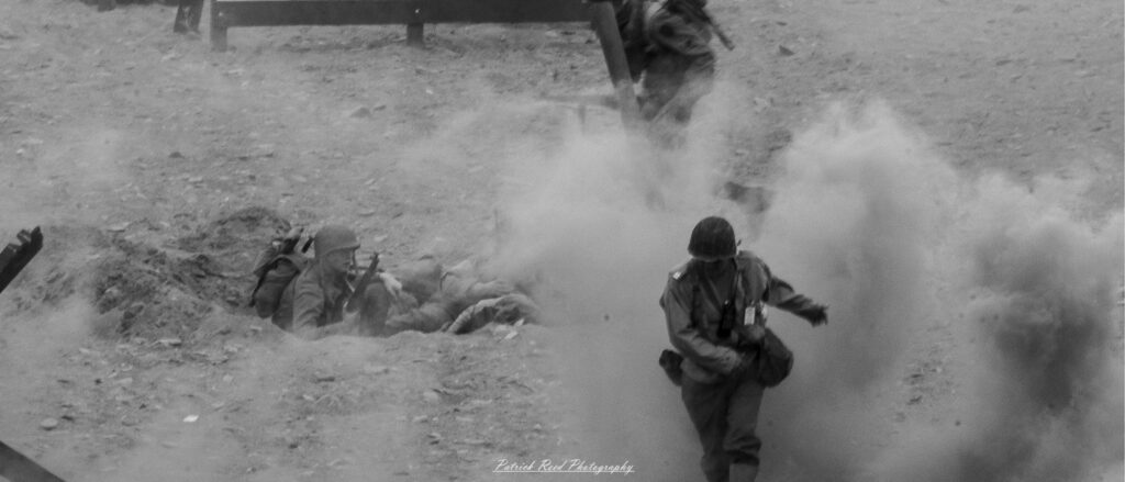 Image of a soldier on a D-Day Beach standing on a battlefield, partially obscured by thick, swirling smoke.